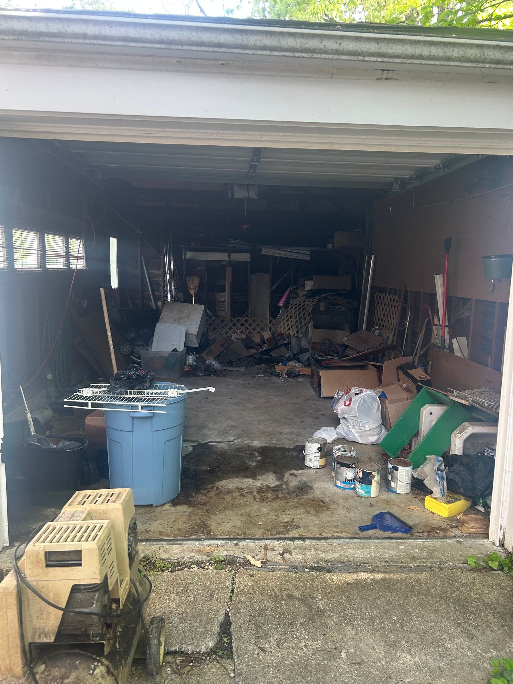 A garage full of stored items and debris before a cleanout
